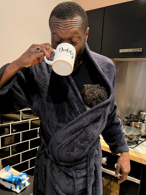 Founder of Kyroo - carrying son in robe 